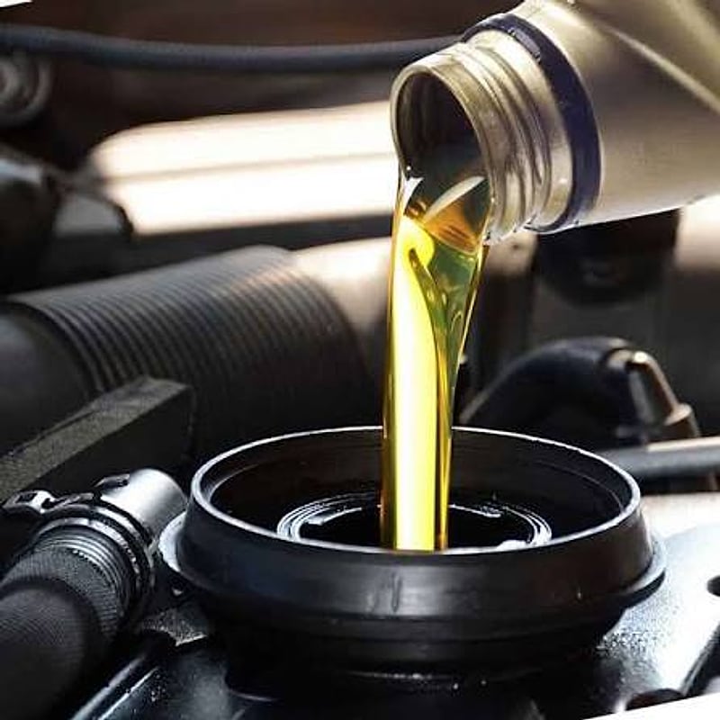 Fresh engine oil being poured during a full vehicle service